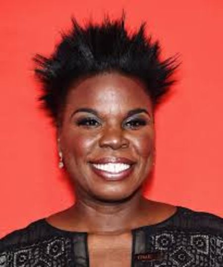TV Star Leslie Jones in a black dress poses for a picture.